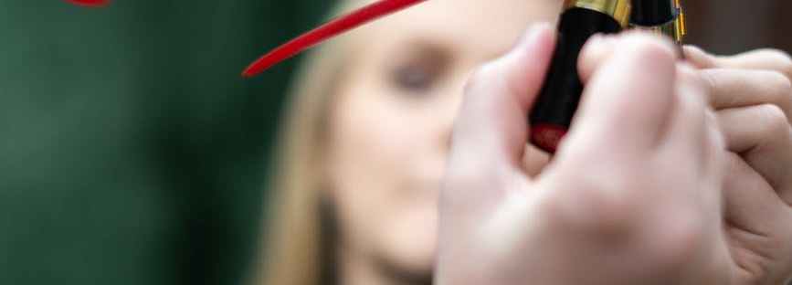 woman in black shirt holding red lipstick